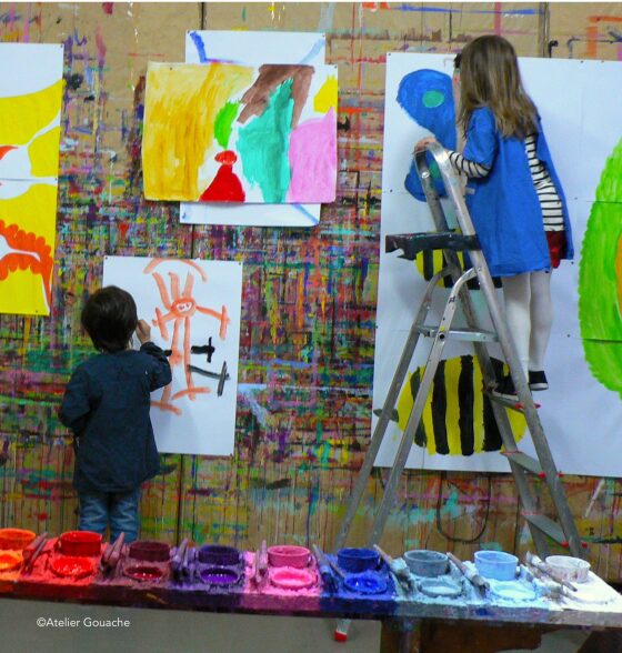 Participants en séance de peinture libre, feuilles grand format punaisées au mur